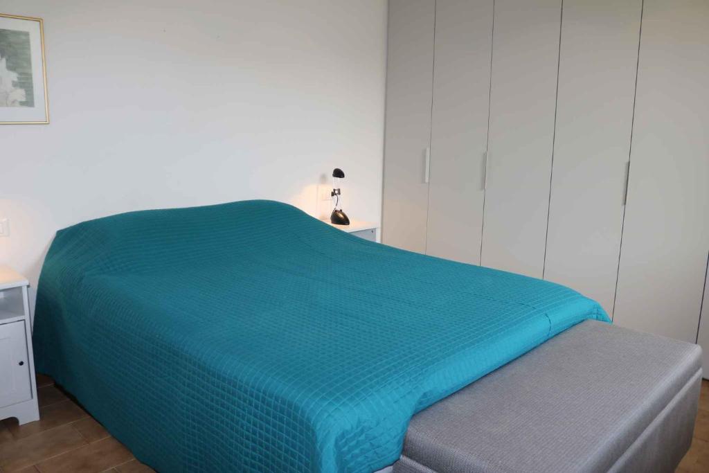 łóżko z niebieską kołdrą w pokoju w obiekcie Studio in Lazise/Gardasee 21938 w mieście Lazise
