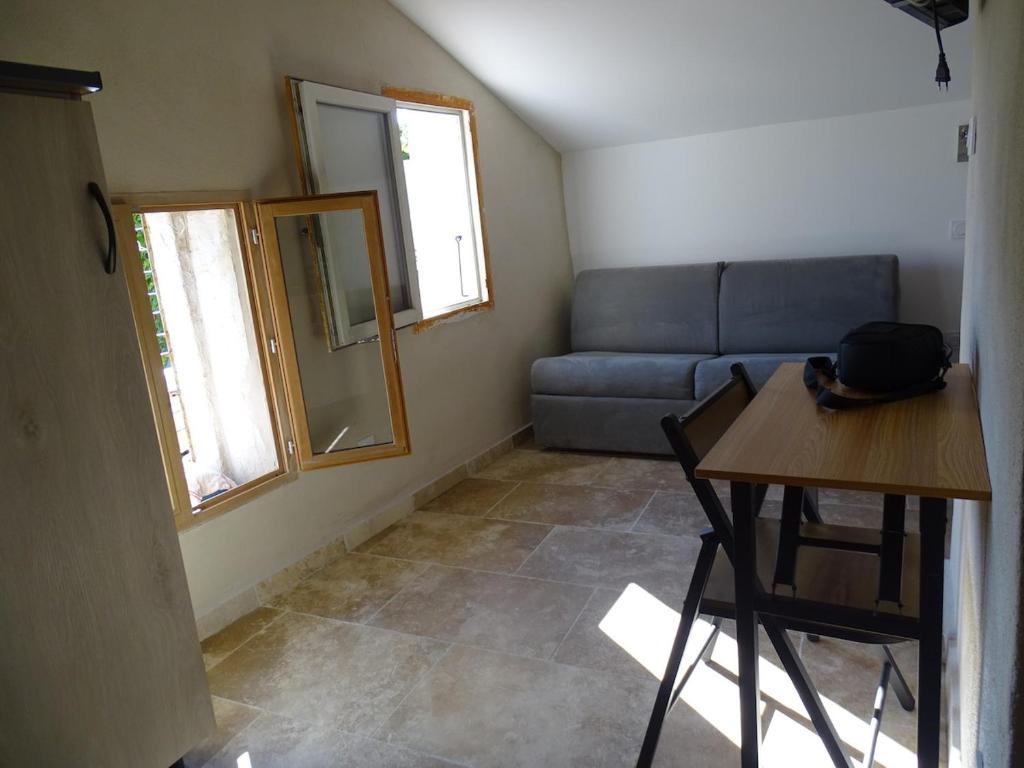 un salon avec un canapé, une table et des chaises dans l'établissement L'essentiel, Arles, à Arles