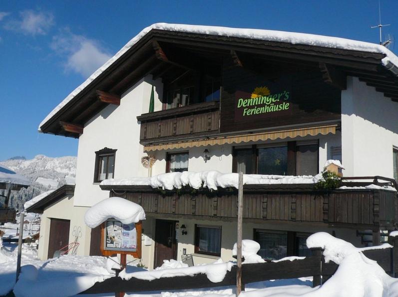 a building with a sign on it in the snow at Denninger's Ferienhäusle in Riezlern