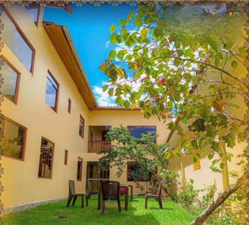 a building with chairs and tables in the yard at Mystic Valley Boutique Hotel in Ollantaytambo