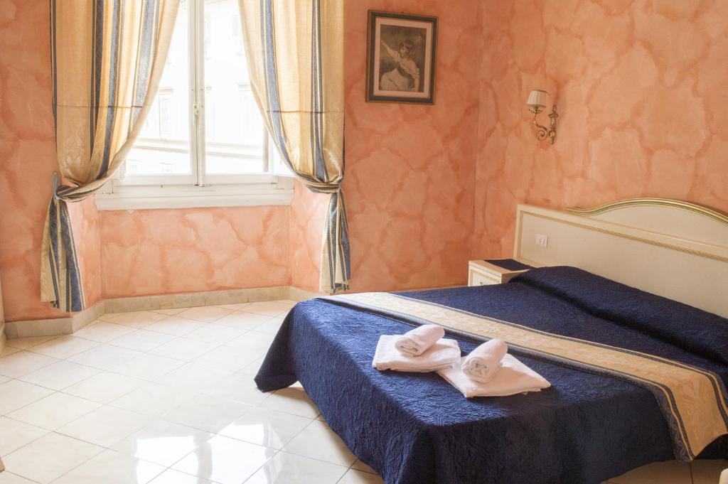 1 dormitorio con 2 toallas en una cama en La Corte Dei Principi - Residenza D'Epoca, en Florencia