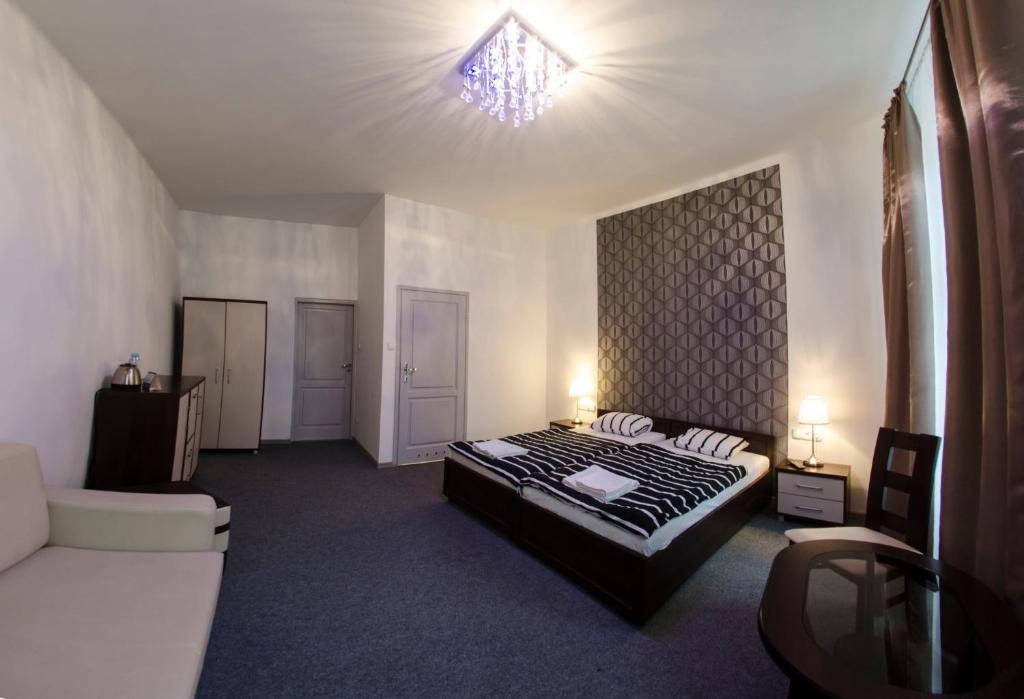 1 dormitorio con cama, sofá y ventana en Brama Hostel, en Cracovia