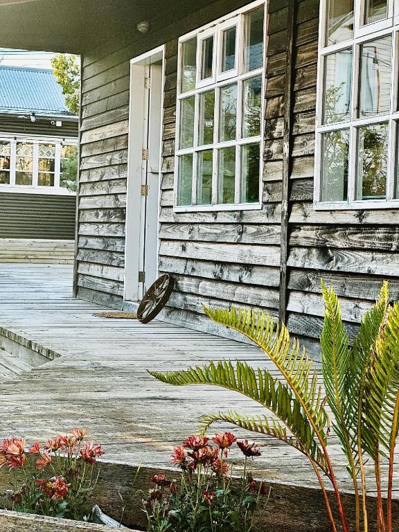 a wooden house with a white door and windows at El Establo in Puerto Natales