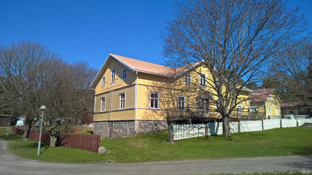 納烏伏的住宿－Majatalo Martta，一座黄色的大房子,前面有栅栏