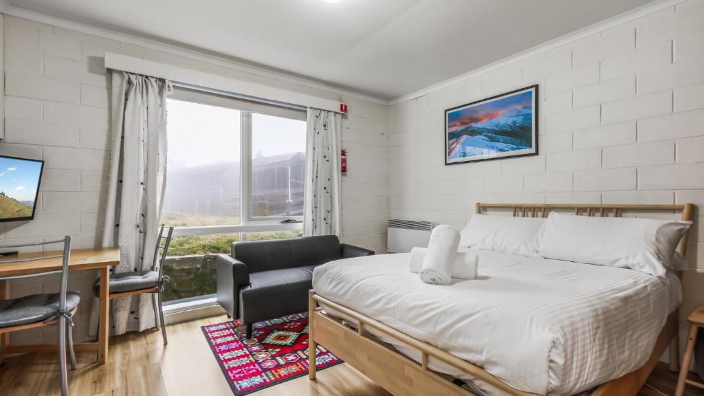 a bedroom with a bed and a desk and a window at Alpine Haven 4 in Mount Hotham