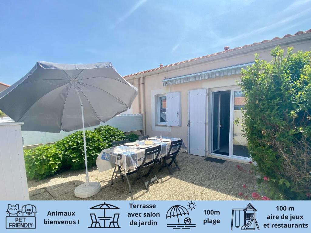 une table avec un parasol devant une maison dans l'établissement Maison à 300m de la plage, avec terrasse, parking privatif, animaux admis ! - FR-1-231-140, à Bretignolles-sur-Mer