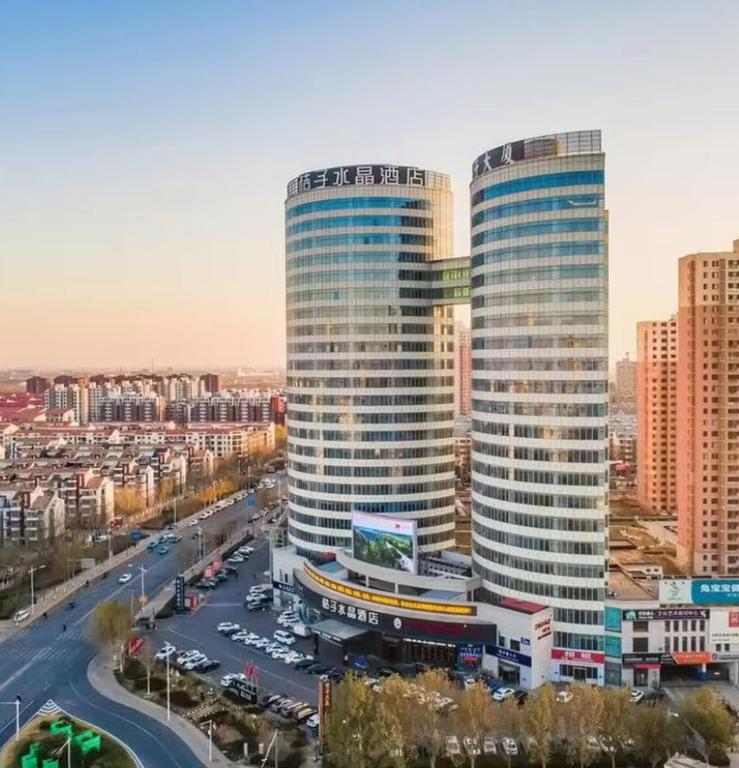 天津Crystal Orange Hotel Tianjin Jinghai Dongfanghong Road的一座城市里有两栋高楼，有一条街道