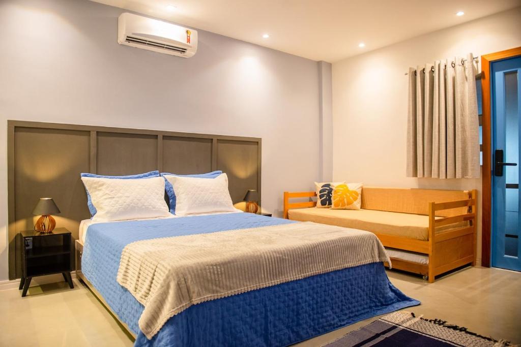 a bedroom with a large bed and a bench at Studio Brisa da Ferradura - Búzios in Búzios