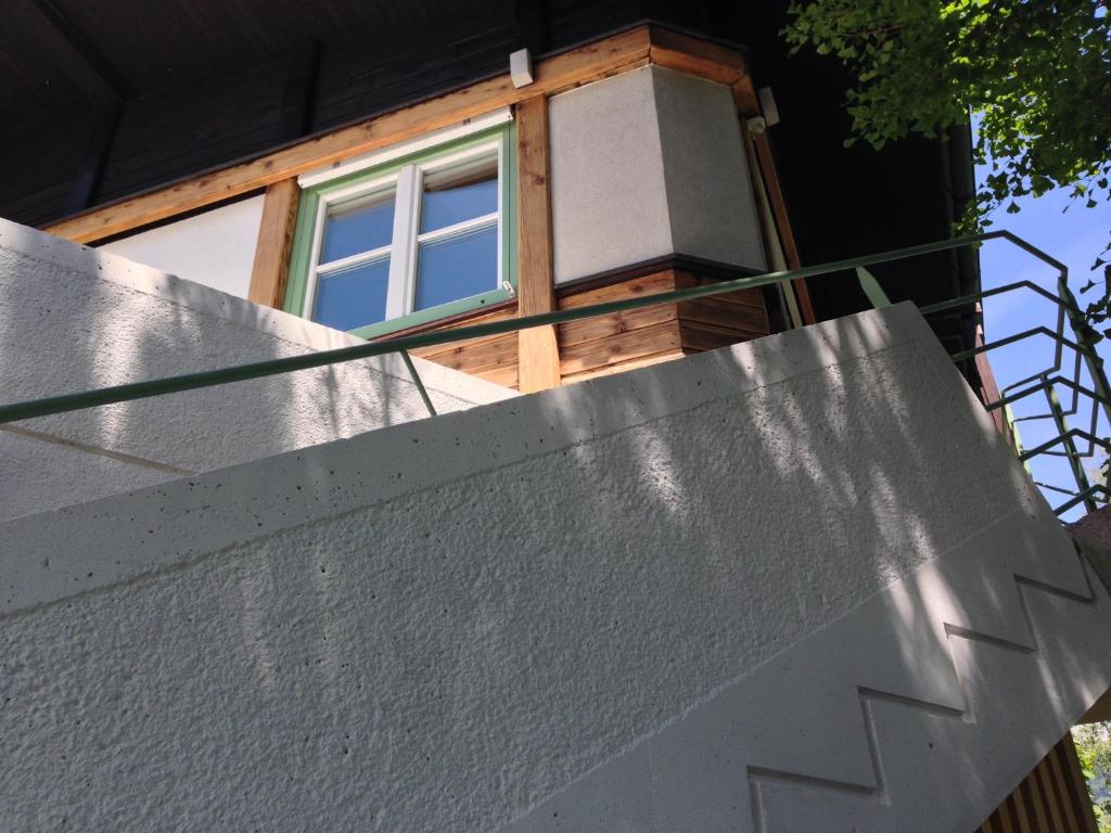 ein Haus mit einem Fenster auf einer Betonwand in der Unterkunft Ferienwohnung Mountaintop in Lienz