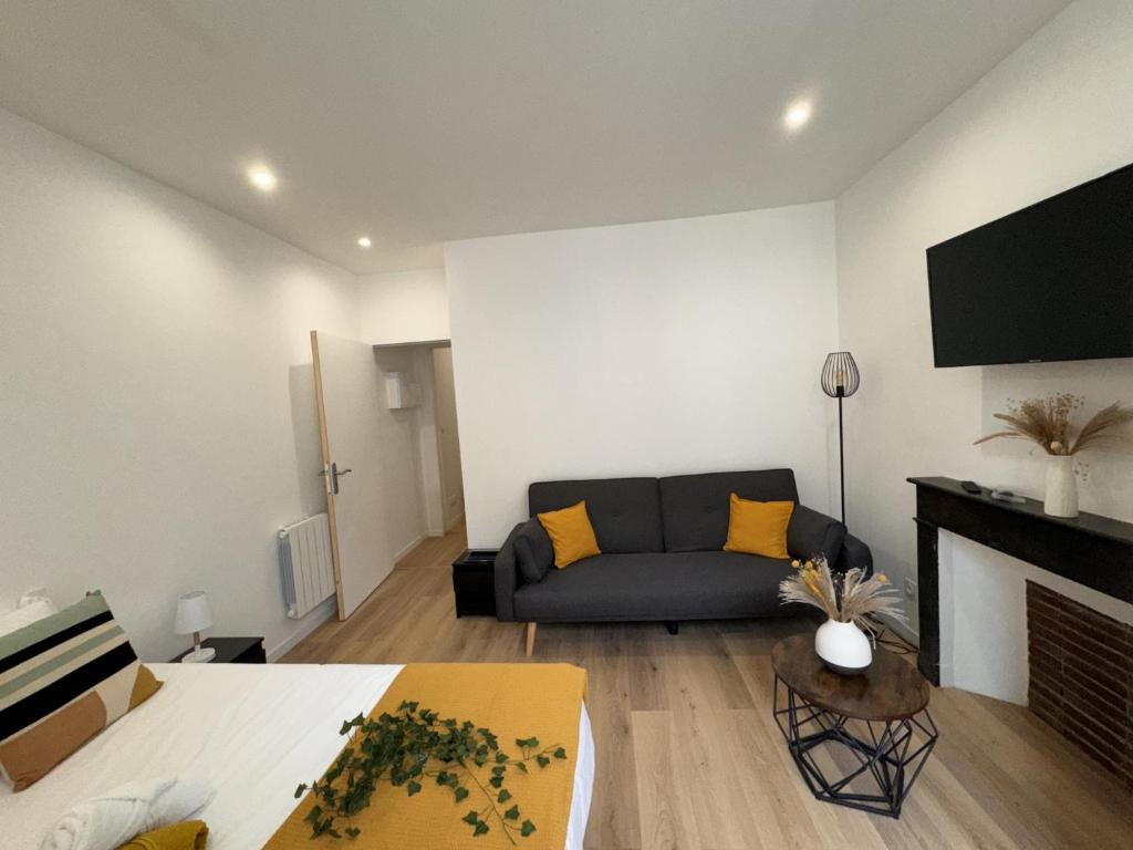 un salon avec un canapé et une cheminée dans l'établissement Cozy Urban Nest Near Le Mans, à Écommoy