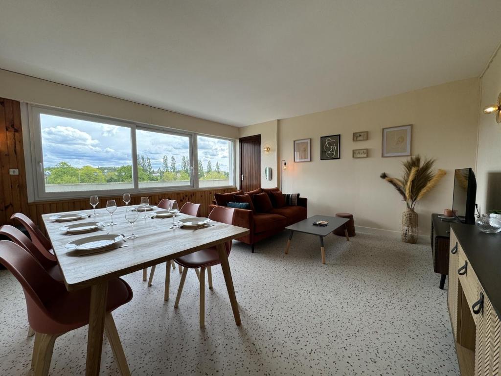 un salon avec une table avec des chaises et un canapé dans l'établissement Apartment in Le Mans near 24H Circuit, au Mans
