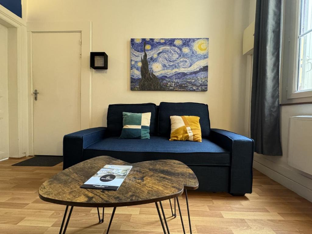 un salon avec un canapé bleu et une table dans l'établissement Apartment in Le Mans near 24 Hours Circuit, au Mans
