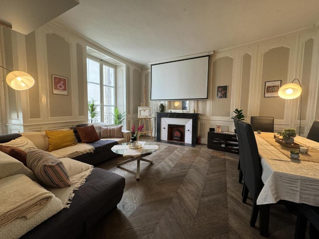 un salon avec un canapé et une télévision dans l'établissement Villa in Le Mans near Plantagenêt City, au Mans