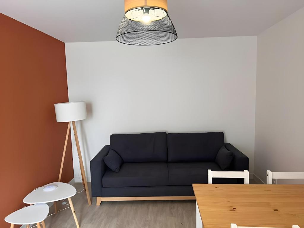un salon avec un canapé noir et une table dans l'établissement Apartment in Ballon near Le Mans Circuit, à Ballon