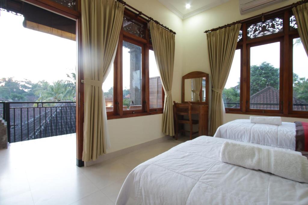 sypialnia z 2 łóżkami i dużymi oknami w obiekcie Taman Ayu Ubud w mieście Ubud
