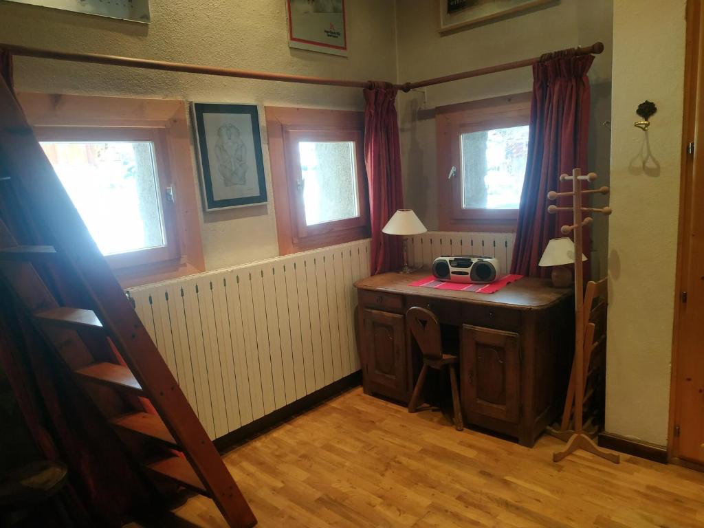 Cette chambre comprend un bureau en bois et 2 fenêtres. dans l'établissement Studio au pied des pistes, centre Val d'Isère, 3 pers, cosy mezzanine, cuisine équipée, WiFi - FR-1-519-37, à Val dʼIsère
