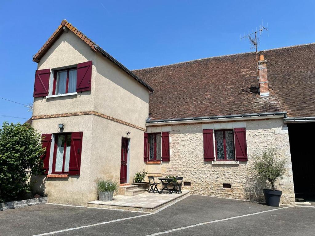 una casa con finestre con persiane rosse e un tavolo da picnic di Gîte charmant à Veuzain-sur-Loire, proche des châteaux - FR-1-491-470 a Veuzain-sur-Loire