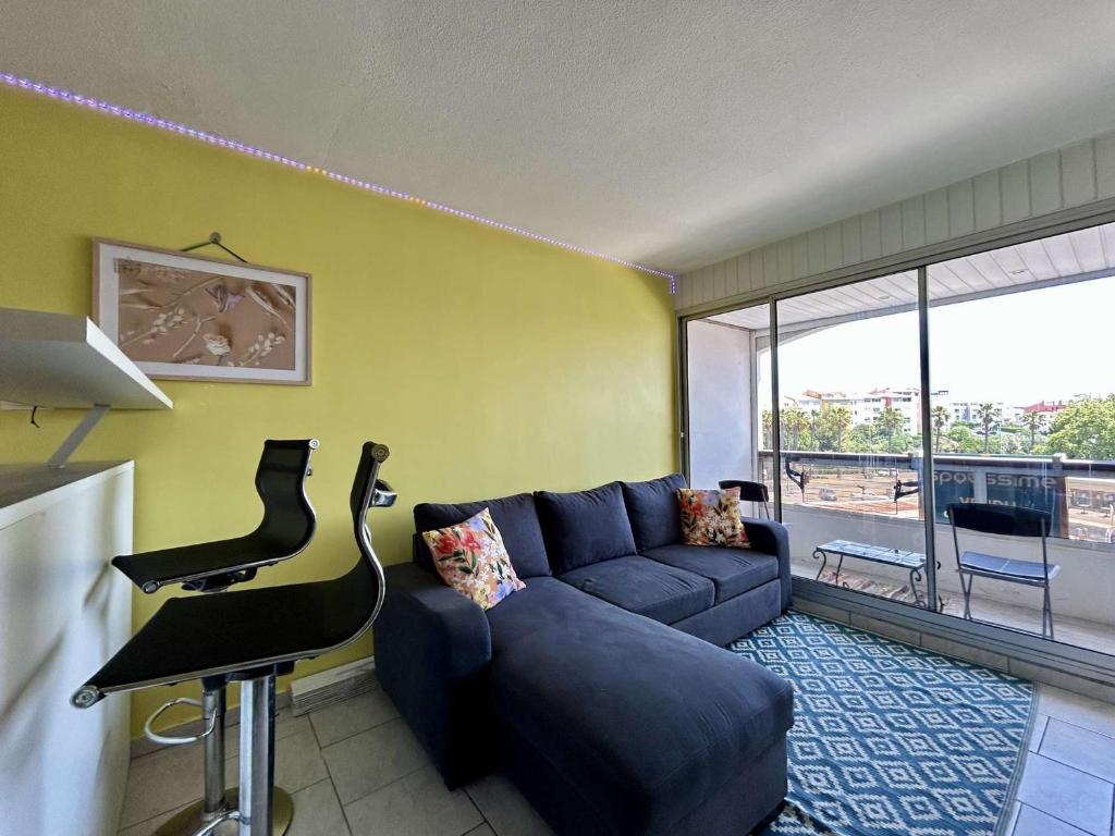 un salon avec un canapé bleu et une table dans l'établissement Studio rénové avec parking au Cap d'Agde - FR-1-249-444, au Cap d'Agde