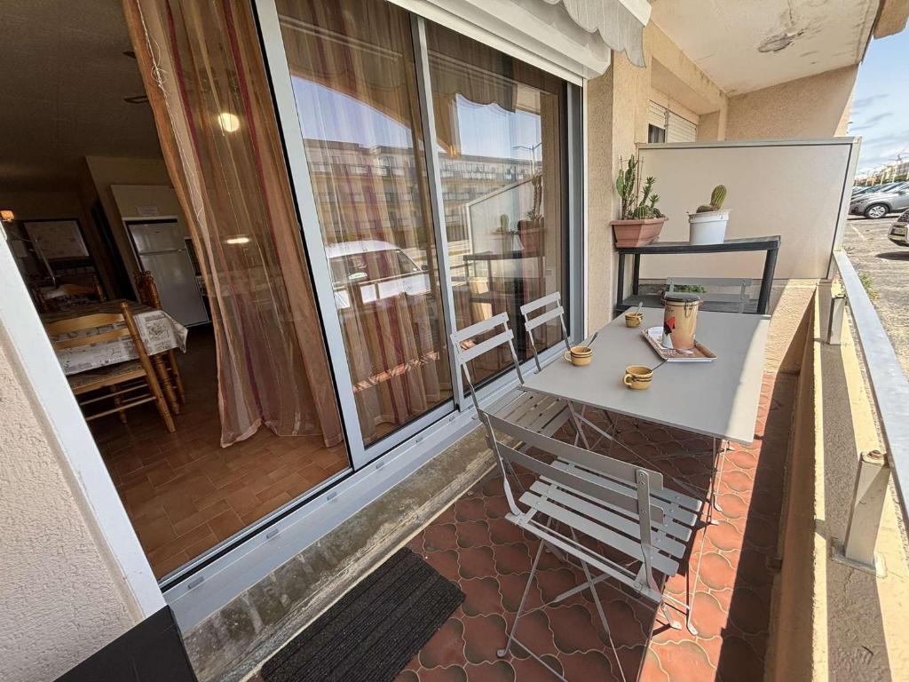 d'un balcon avec une table et une vue sur le patio. dans l'établissement Appartement lumineux RDC 2 pièces avec piscine proche mer - FR-1-229C-111, à Port-la-Nouvelle