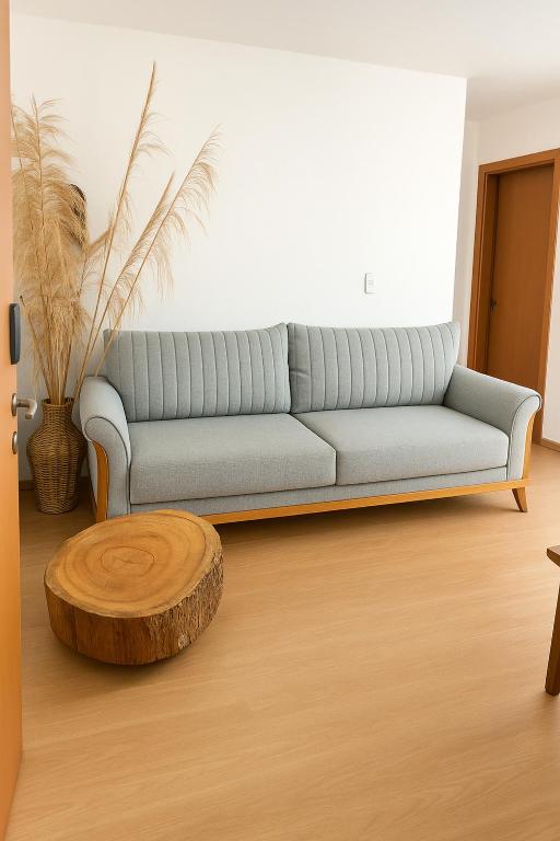 a living room with a couch and a coffee table at Apto Prox Parque do Sabia e Aeroporto in Uberlândia