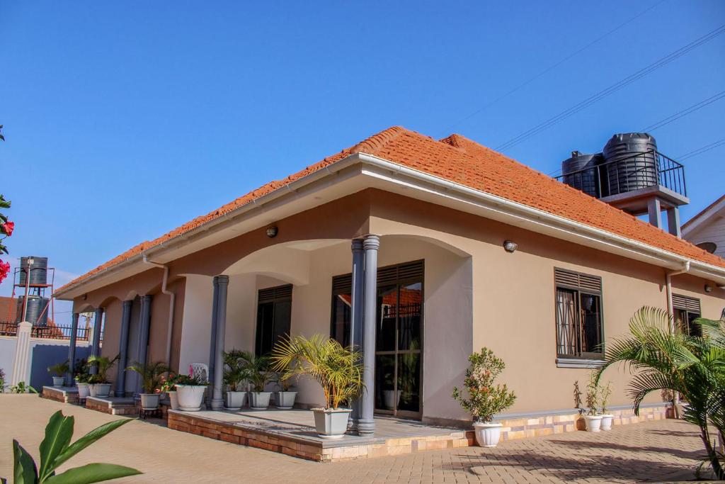 una piccola casa con delle piante davanti di Grafo a Kampala