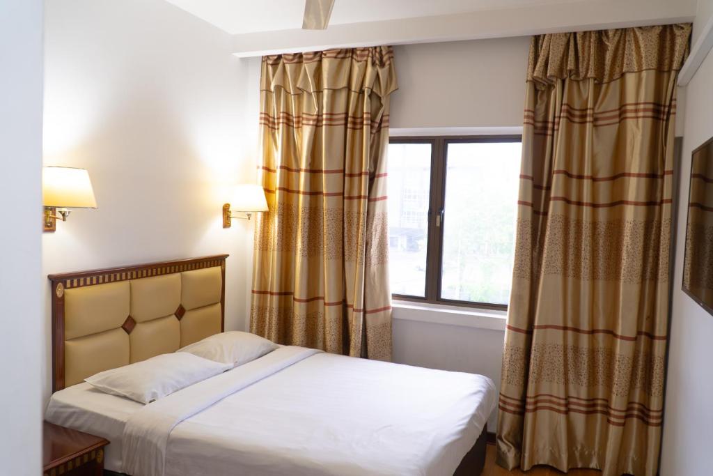 Postel nebo postele na pokoji v ubytování Borneo Suites Hotel