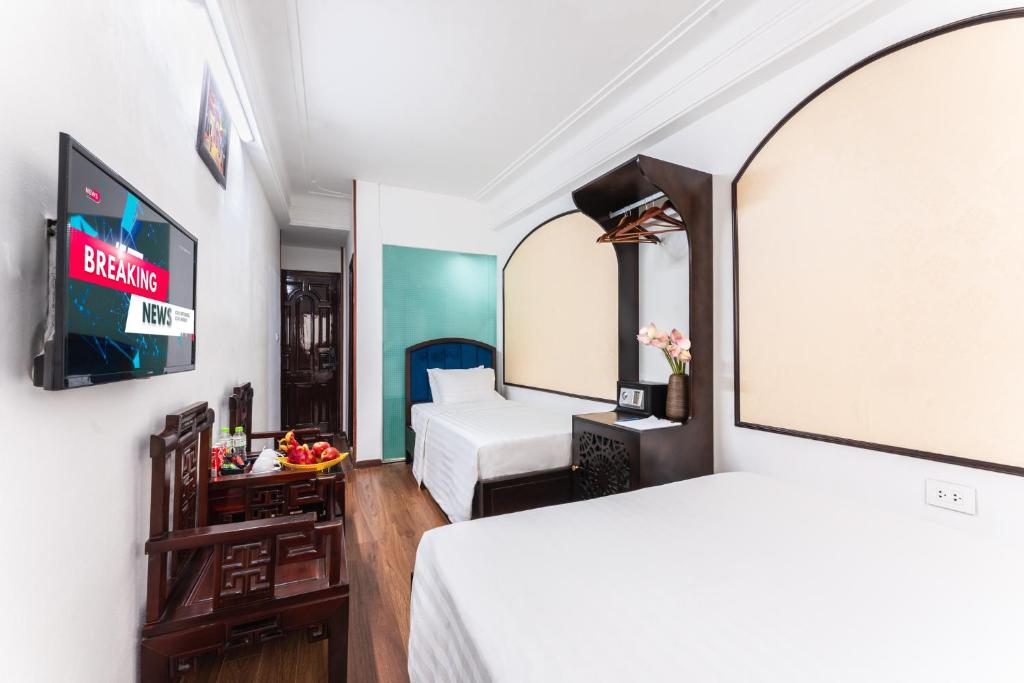Postel nebo postele na pokoji v ubytování Little Hanoi Hotel