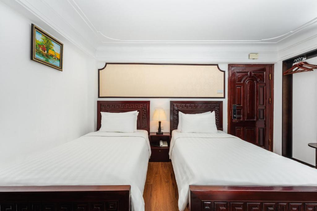 Postel nebo postele na pokoji v ubytování Little Hanoi Hotel