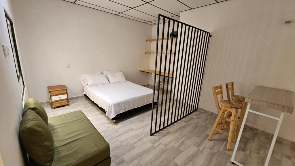 a bedroom with a bed and a table and a desk at Apartaestudio tipo Loft tranquilo cerca al Parque in Armenia