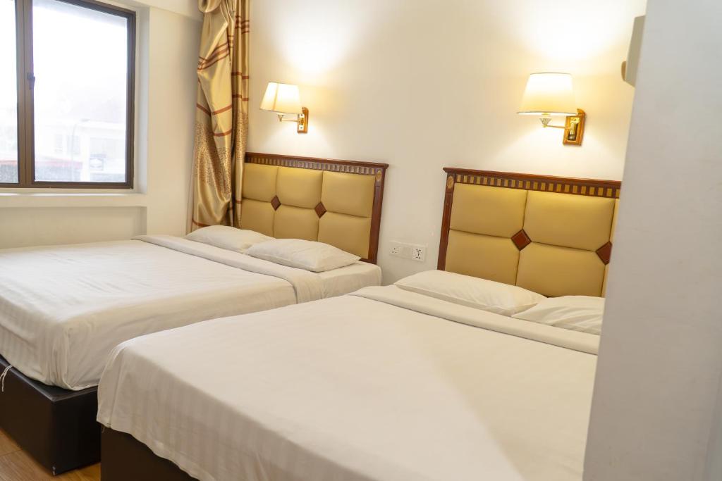 Postel nebo postele na pokoji v ubytování Borneo Suites Hotel