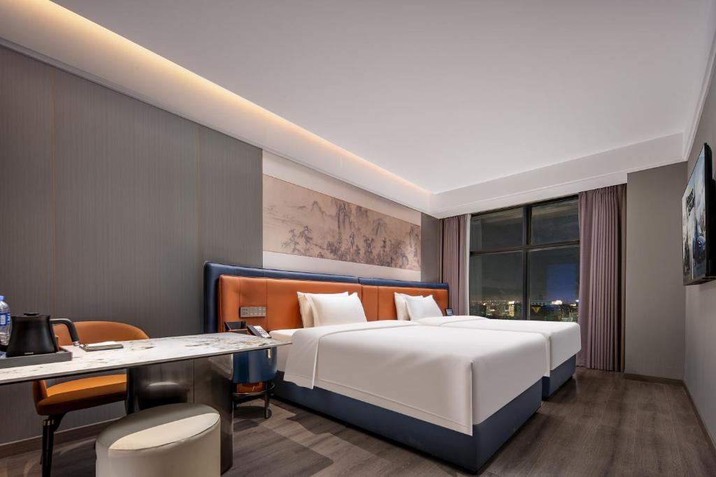Postel nebo postele na pokoji v ubytování Yuanshe Yiju Hotel