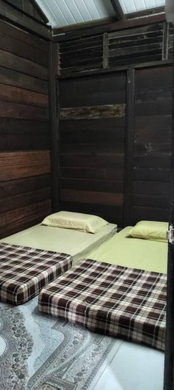 Postel nebo postele na pokoji v ubytování Rumah Kayu Masjid Zahir