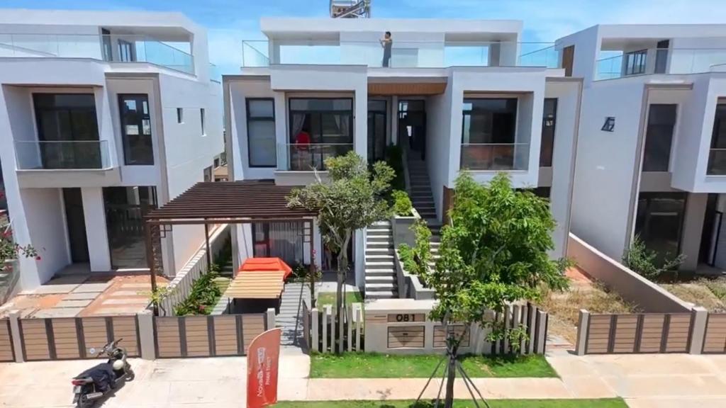 una casa in periferia con uno scooter parcheggiato davanti di VIERA Novaworld Phan Thiet Golf Villa a Phan Thiet