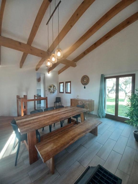 ein großes Esszimmer mit einem Holztisch in der Unterkunft Villa Padulina au bord de la mer avec piscine in Galeria