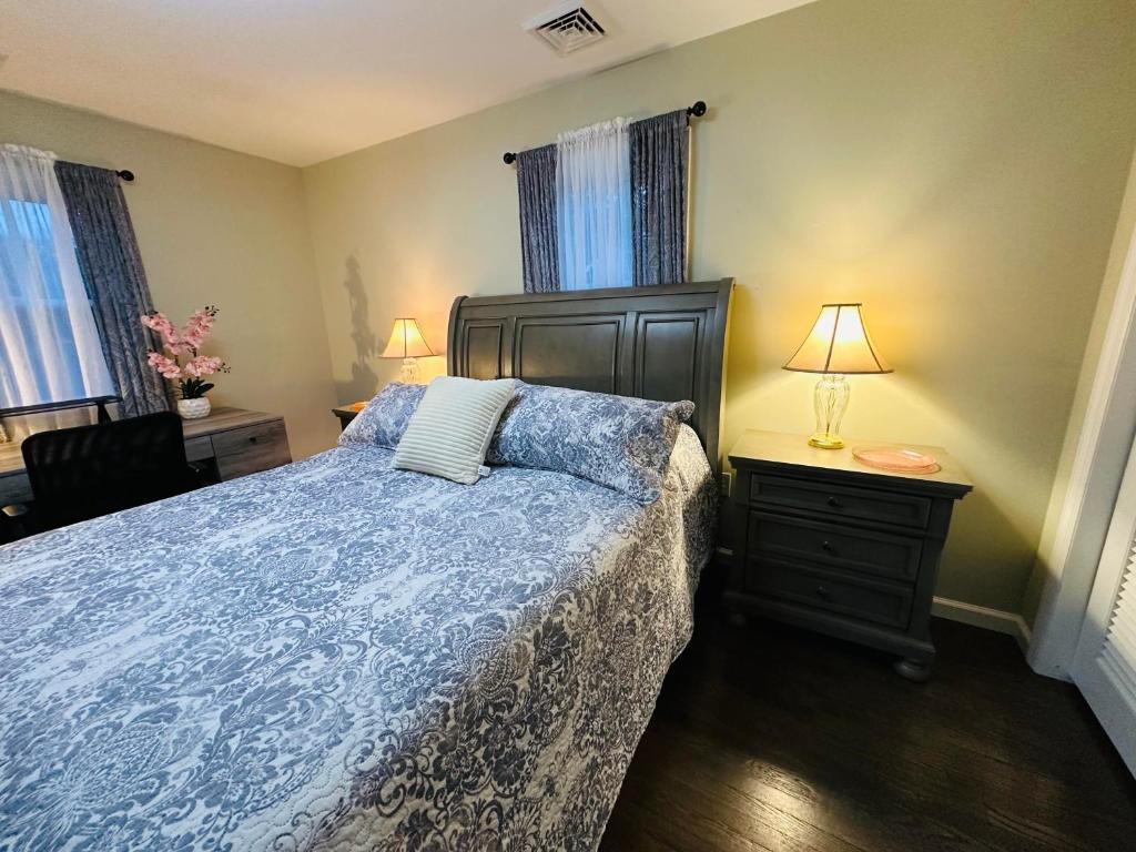 a bedroom with a bed with a blue comforter at The Soft Landing Elle's Home Near NYC in Trenton