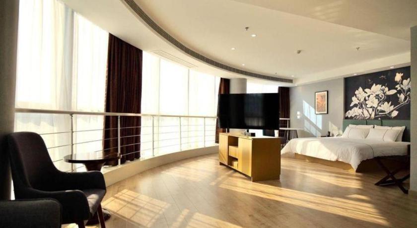 une chambre avec un lit et une télévision dans l'établissement Magnotel Nanjing Lishui Baota Bei Road, à Lishui