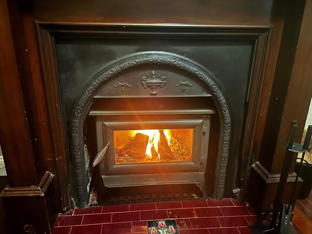 a fireplace with a fire inside of it at South Terrace House - walk to everything ! in South Fremantle