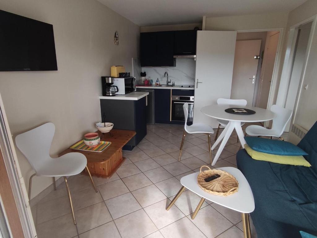 un salon avec un canapé et une table et une cuisine dans l'établissement Charmant appartement 2 pièces avec loggia et parking à deux pas de la plage - FR-1-712-93, à Villers-sur-Mer