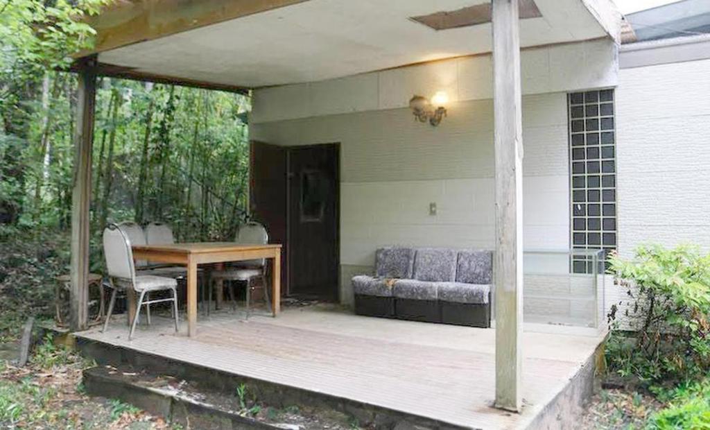 a covered porch with a table and a couch at Shinfuji Auto Campsite - Vacation STAY 53263v in Kami-ide