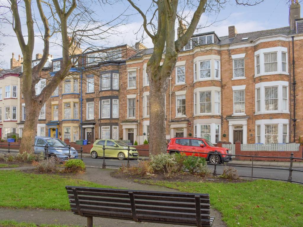 a park bench in front of a large brick building at Driftwood in Scarborough