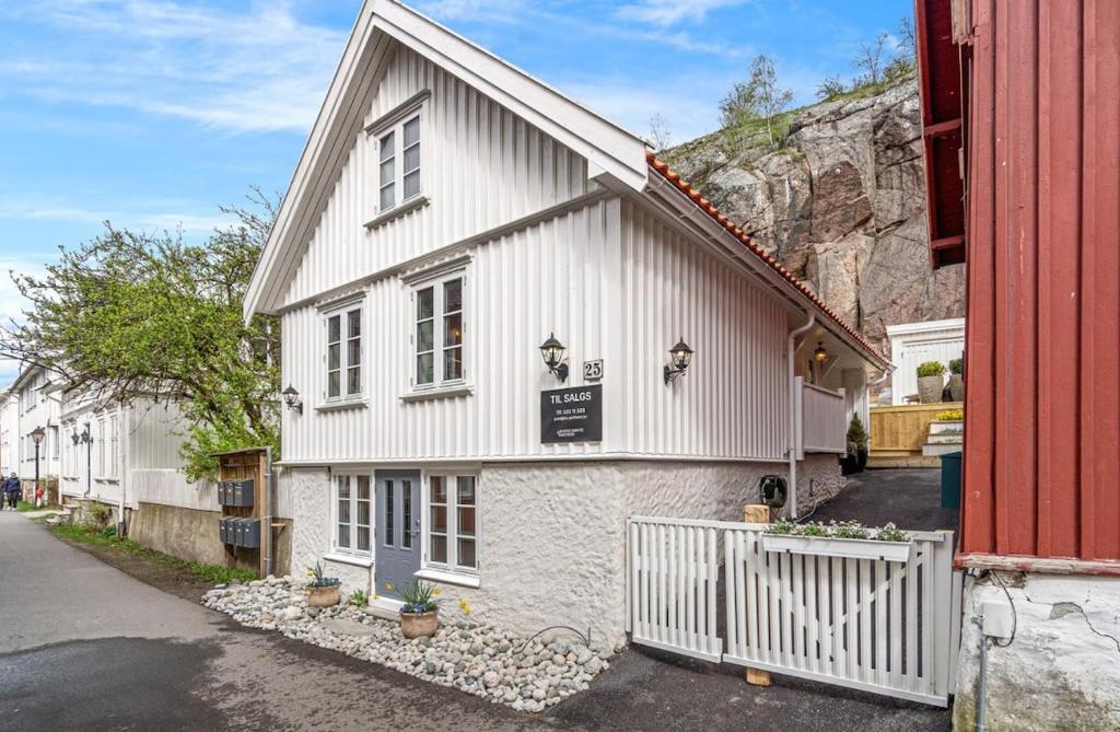a white building with a sign on the side of it at Idylliske Nordbyen - Brygga i Tønsberg in Tønsberg