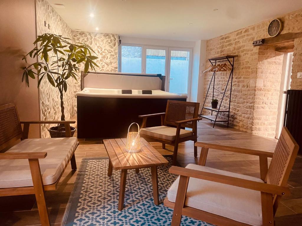 Una sala de estar con un piano, una mesa y bancos. en La Chance Spa cottage 6 personnes, en Orges