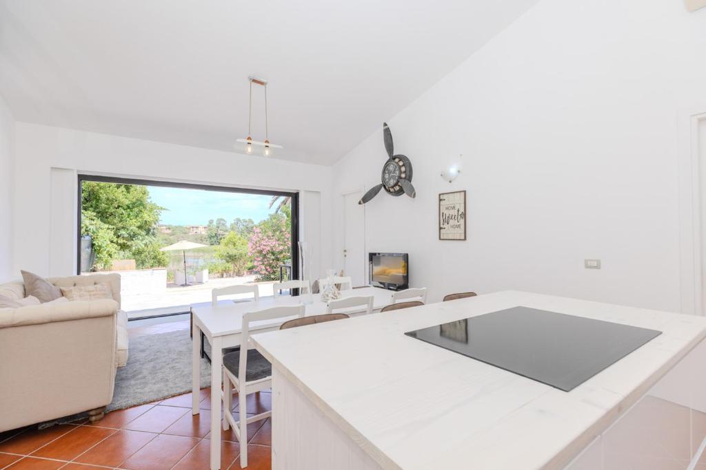 eine Küche und ein Wohnzimmer mit einer großen weißen Arbeitsplatte in der Unterkunft Casa delle brezze - A due passi dalla riva in Olbia