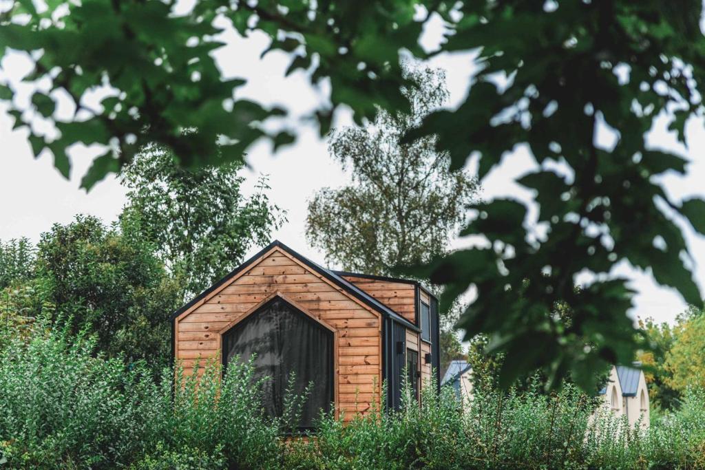 a small brick building with a large door at Paradise Home by Tiny Away in Bessé-sur-Braye