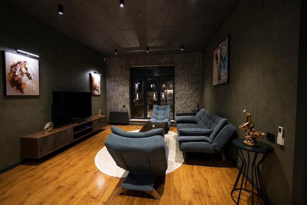 a living room with couches and a flat screen tv at Luxury Beachfront Villa with Indoor Pool & BBQ in Baku