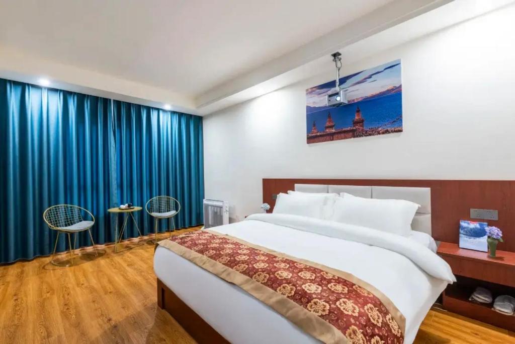 a bedroom with a large bed and blue curtains at Feng Hui Snow Mountain Resort Hotel Deqin Feilai Temple Branch in Shengping