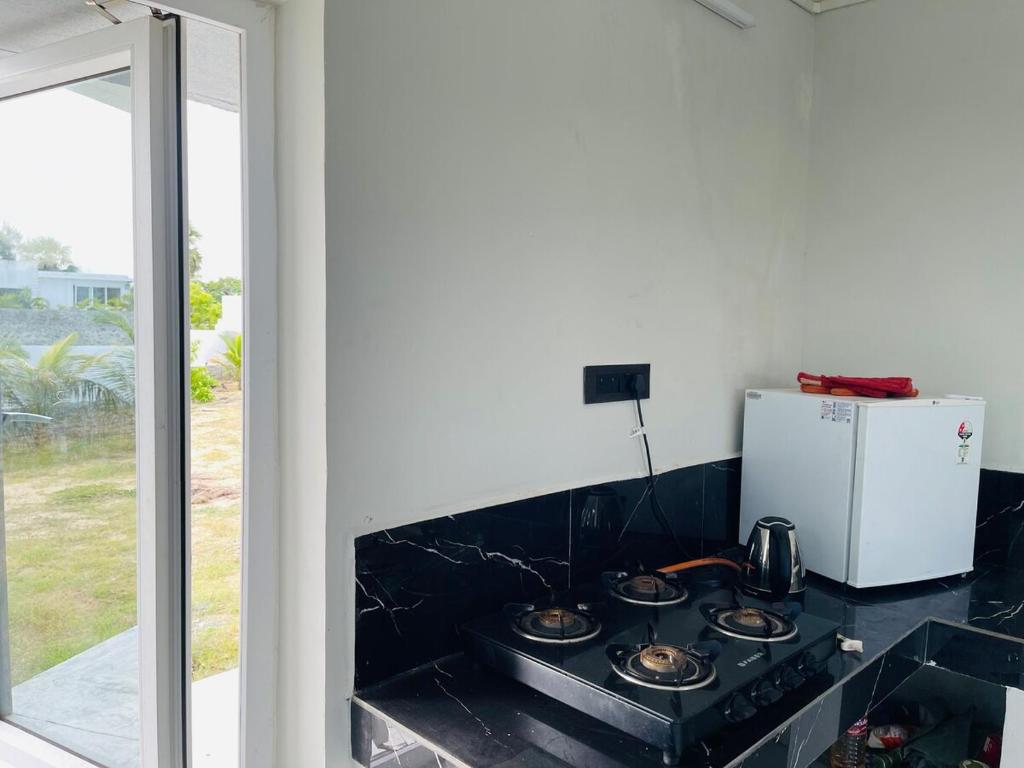 a kitchen with a stove and a refrigerator at The A-Frame house in Kūvattūr