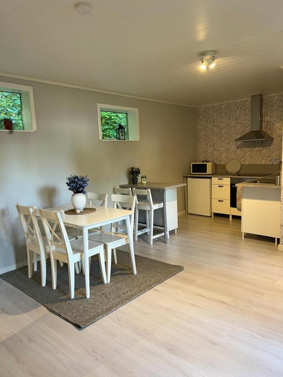 a dining room and kitchen with a table and chairs at Nyrenoverad stuga på Mellersta Öland in Borgholm
