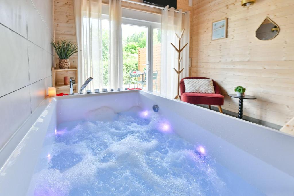 a bathtub with lights in a room with at Le Filet Tendu in Marmoutier