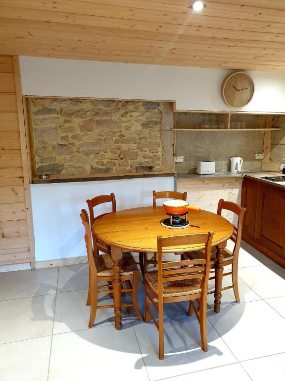 - une table et des chaises en bois dans la cuisine dans l'établissement Gîte Le 1704, à Les Combes